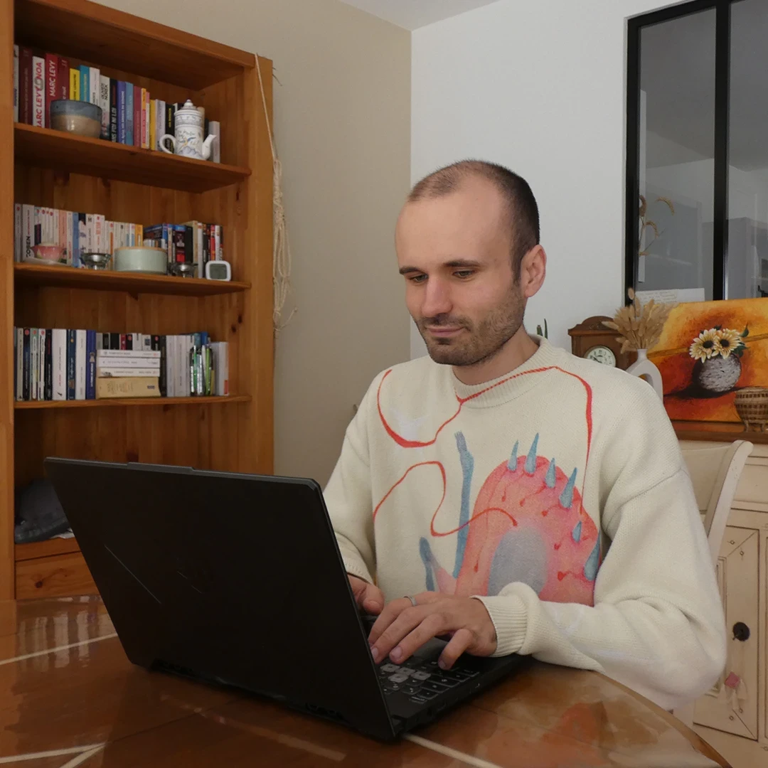 Antoine Koe, développeur web freelance spécialisé WordPress, au travail sur son ordinateur